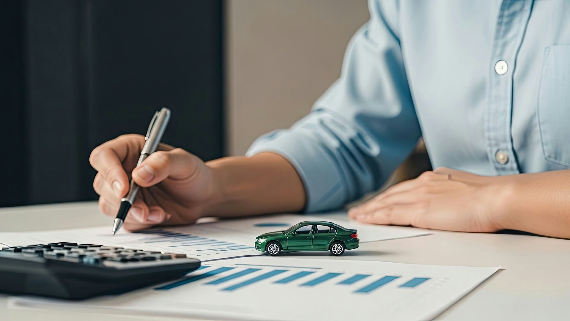 Ein Mann berechnet mit Taschenmesser und Papier die Kosten für sein Auto.